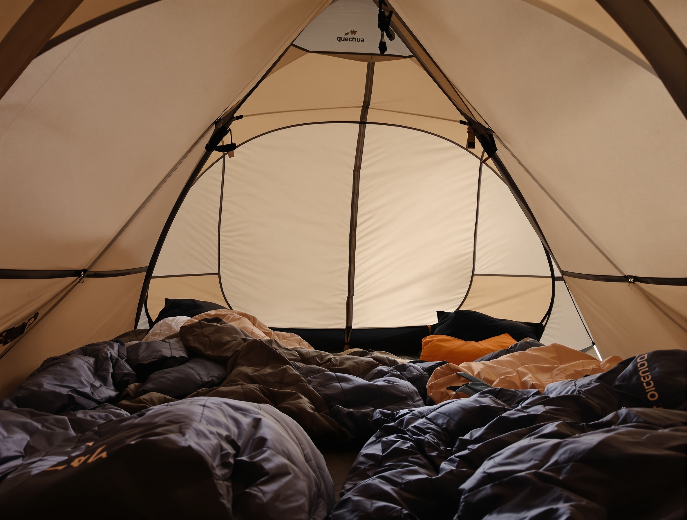 Intérieur d'une tente Quechua 3 places avec la technologie Fresh & Black, illustrant l'obscurité même en plein jour.